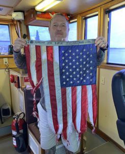 Photo of member holding battered flag